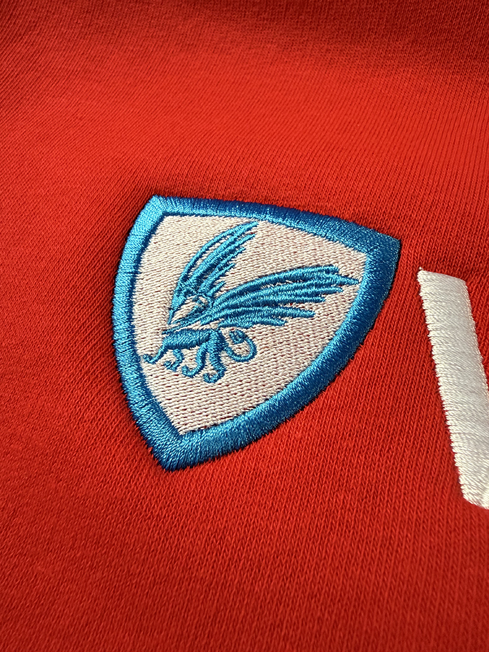 Geborduurd wapen-embleem op rood textiel, Visualprint borduurwerk